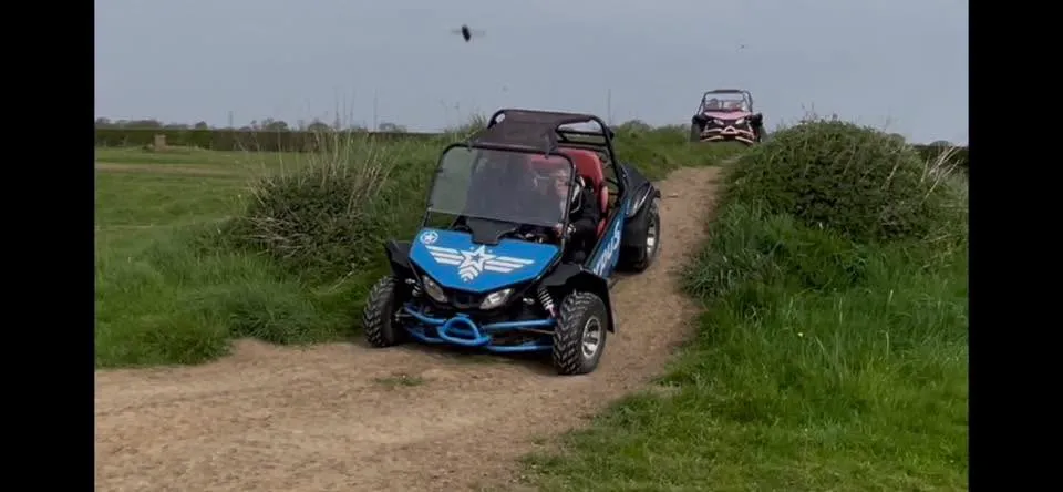 Buggy powering down a roller on the dirt track course