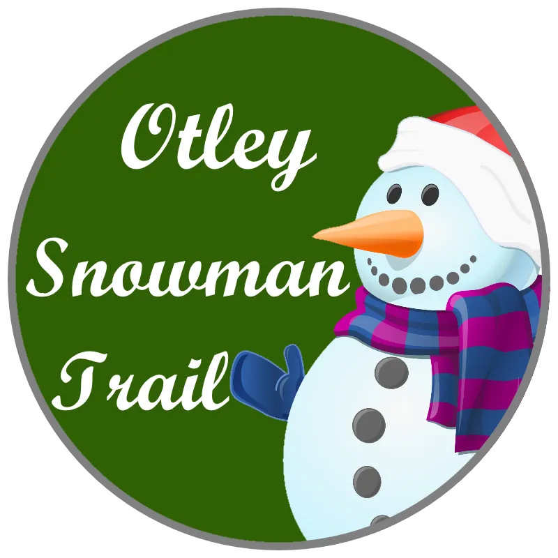 Decorated snowman on display in a shop window for the Otley Snowman Trail
