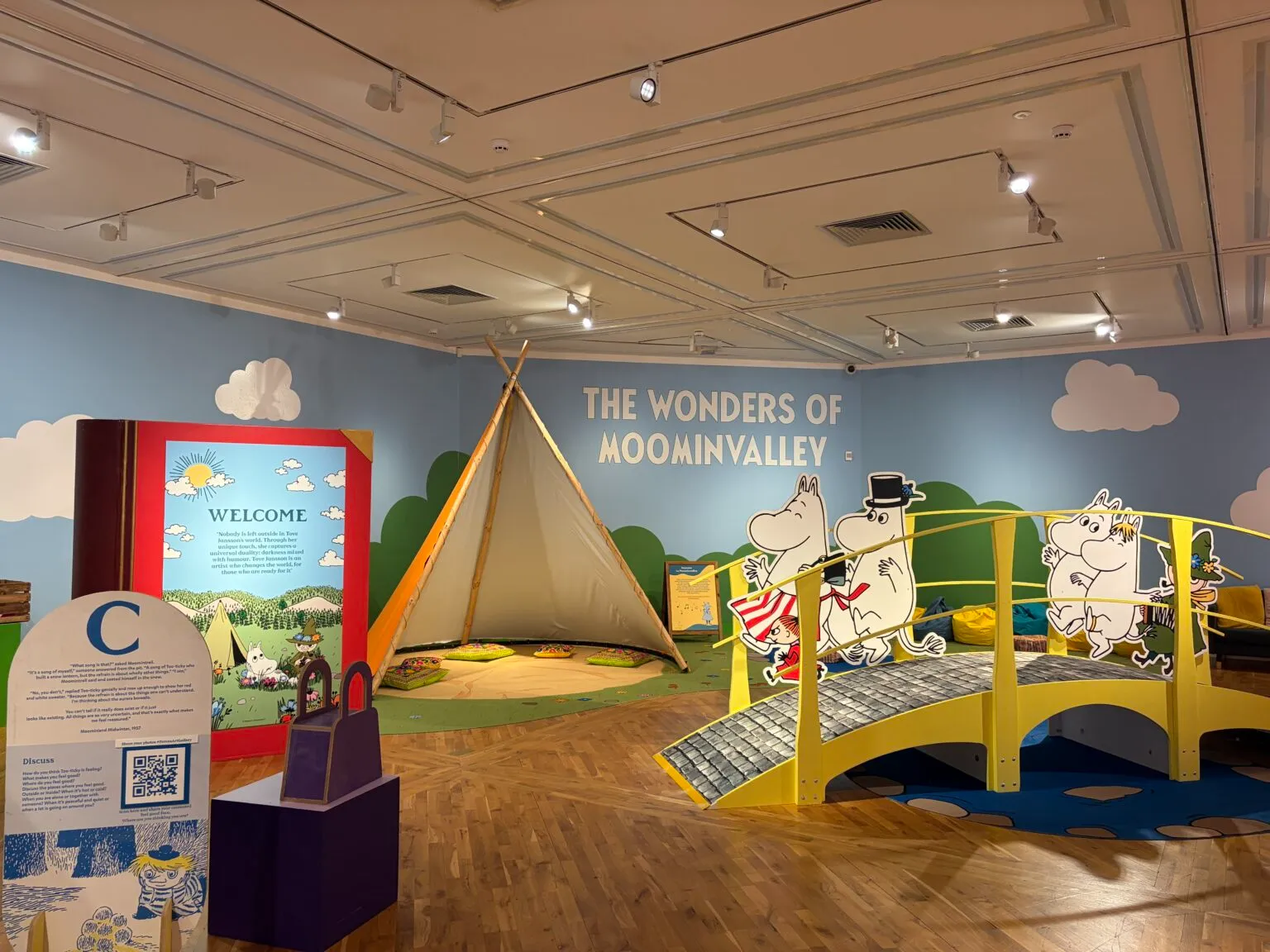 View of the main room at the Moomin exhibition at Ferens Art Gallery, wuth the Moomin bridge, tent, outdoor scene and giant book 
