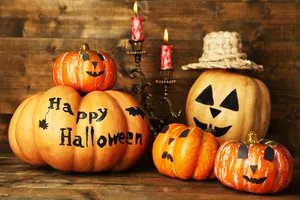 differnt size pumpkins, some with faces, one says happy halloween, one in a hat