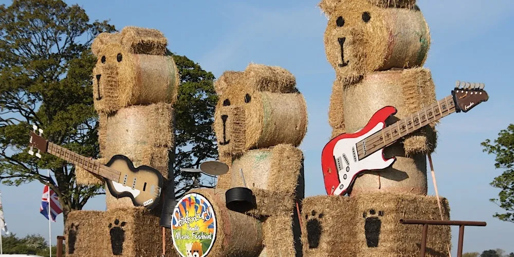 hay bales made to look like teddy bears playing musical instruments at Staxtonbury Festival in July