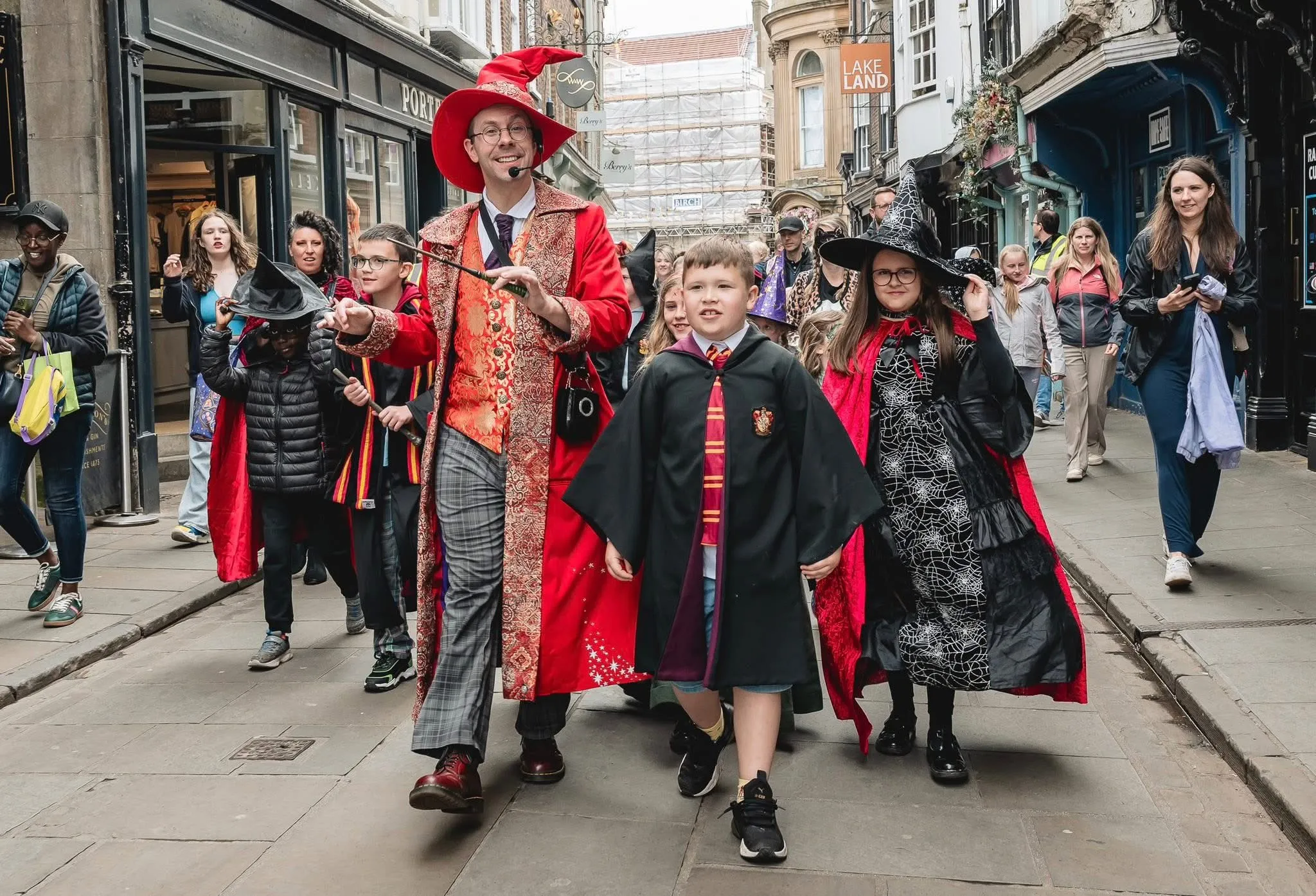 Wizard of York leading the Wizardfest parade in York with children dressed as witches, wizards and magical characters