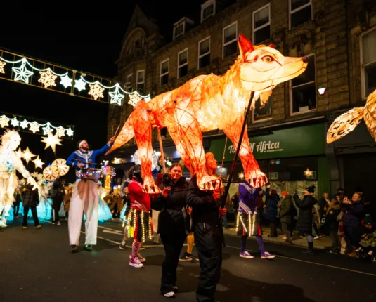 People walking with a huge fox lantern, part of the Light Up Wakefield event in November.