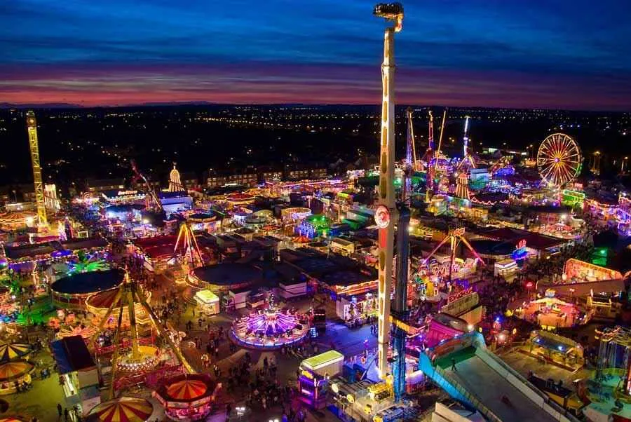 Illuminated ferris wheel and fairground rides at night during Hull Fair on Walton Street