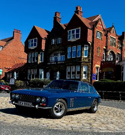 Classic cars lined up on the North Yorkshire coast at Hotel Victoria in Robin Hood's Bay