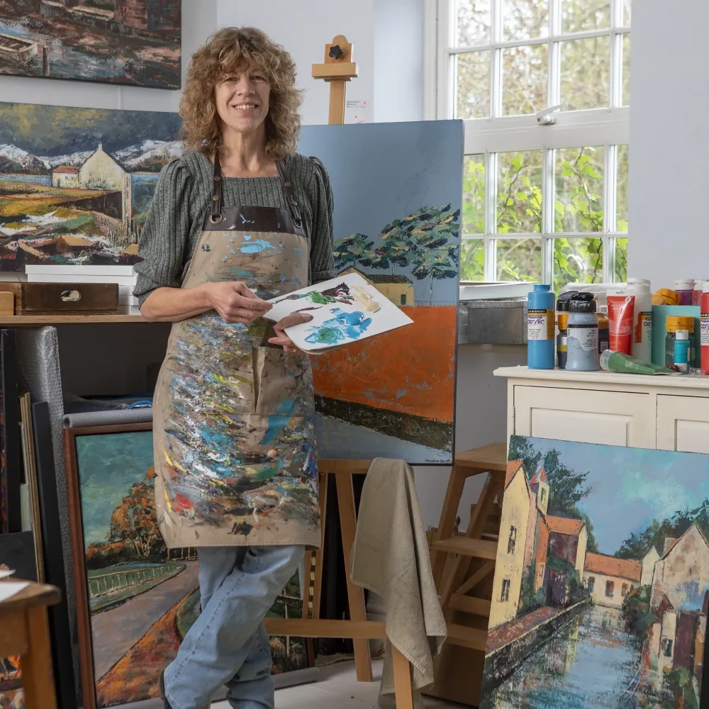 Artist standing next to an easel at Staithes Festival of Art and Heritage