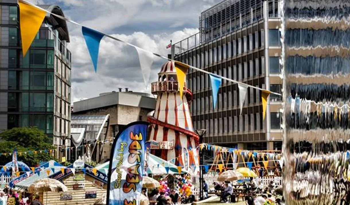 Beach at Sheffield Peace Gardens with funfair and summer fun for the Sheffield by the sea event in the school summer holidays