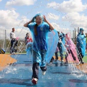 Child running through jets of water at Aqua tek at Magna Science adventure centre in Rotherham