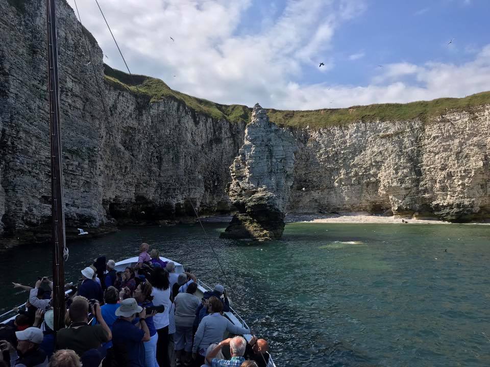 front of the Yorkshire belle boat with people admiring the Flamborough chalk cliffs
