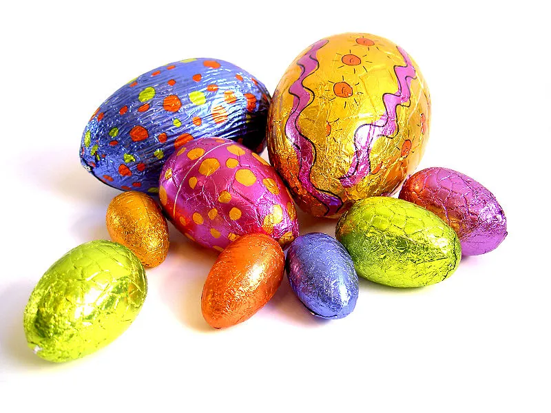 cluster of chocolate eggs all wrapped in brightly coloured foil.