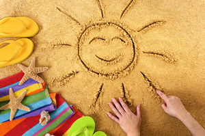 Smiley sun drawn in sand