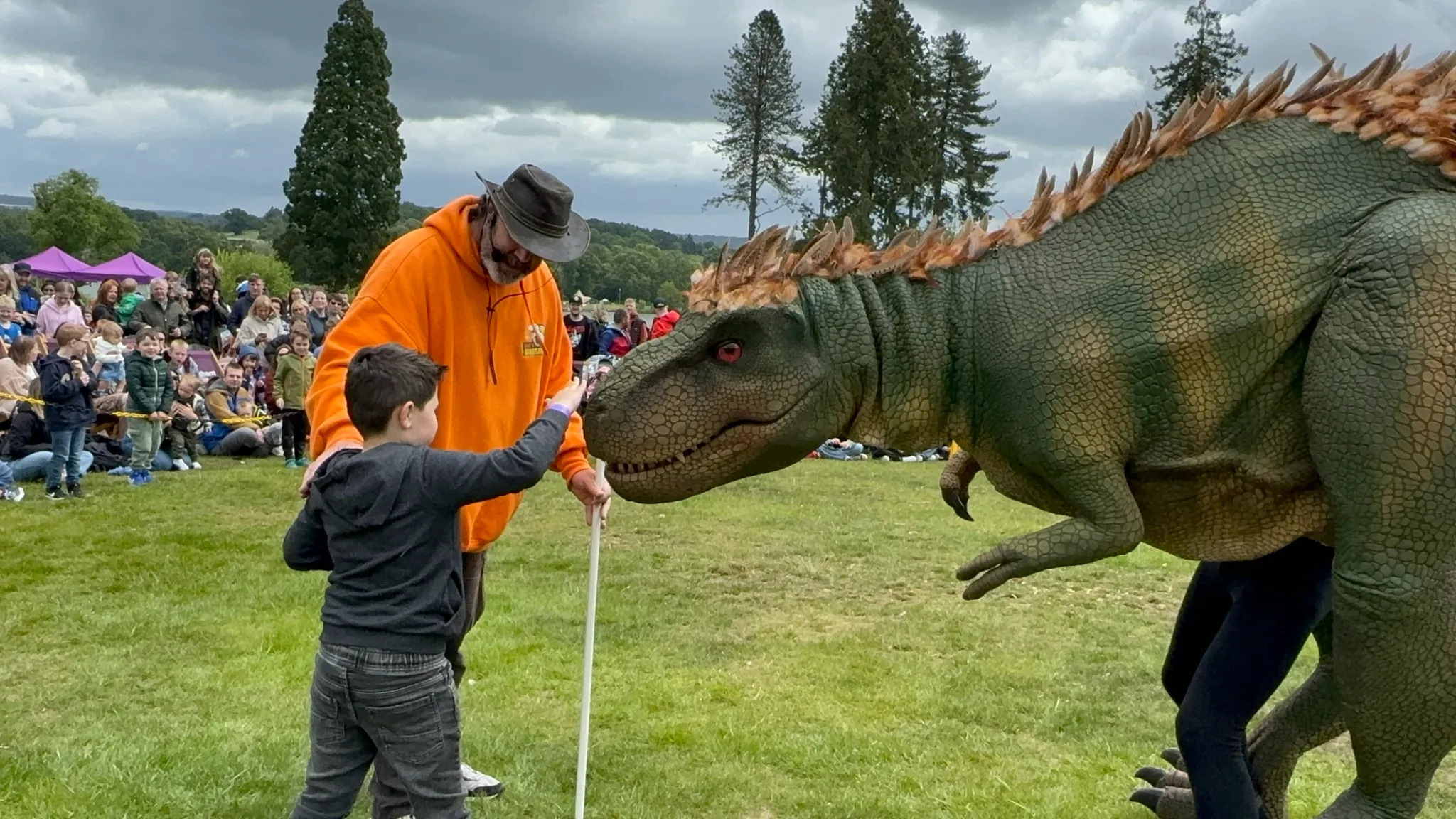 Dino handler with his t-rex, helping a young boy pet the dino at National Coal Mining event in March in Yorkshire.