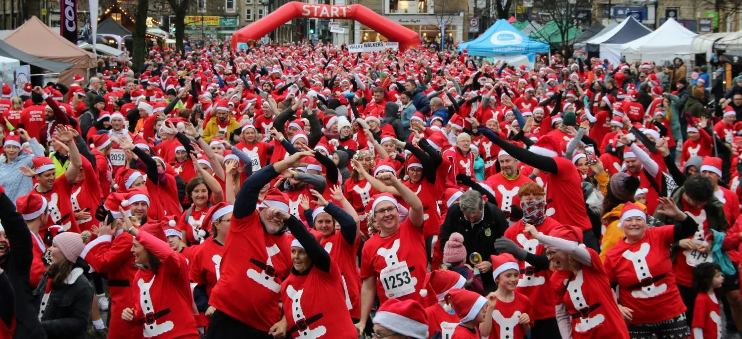 100's of people in red santa tops warming up for the Santa Fun Run