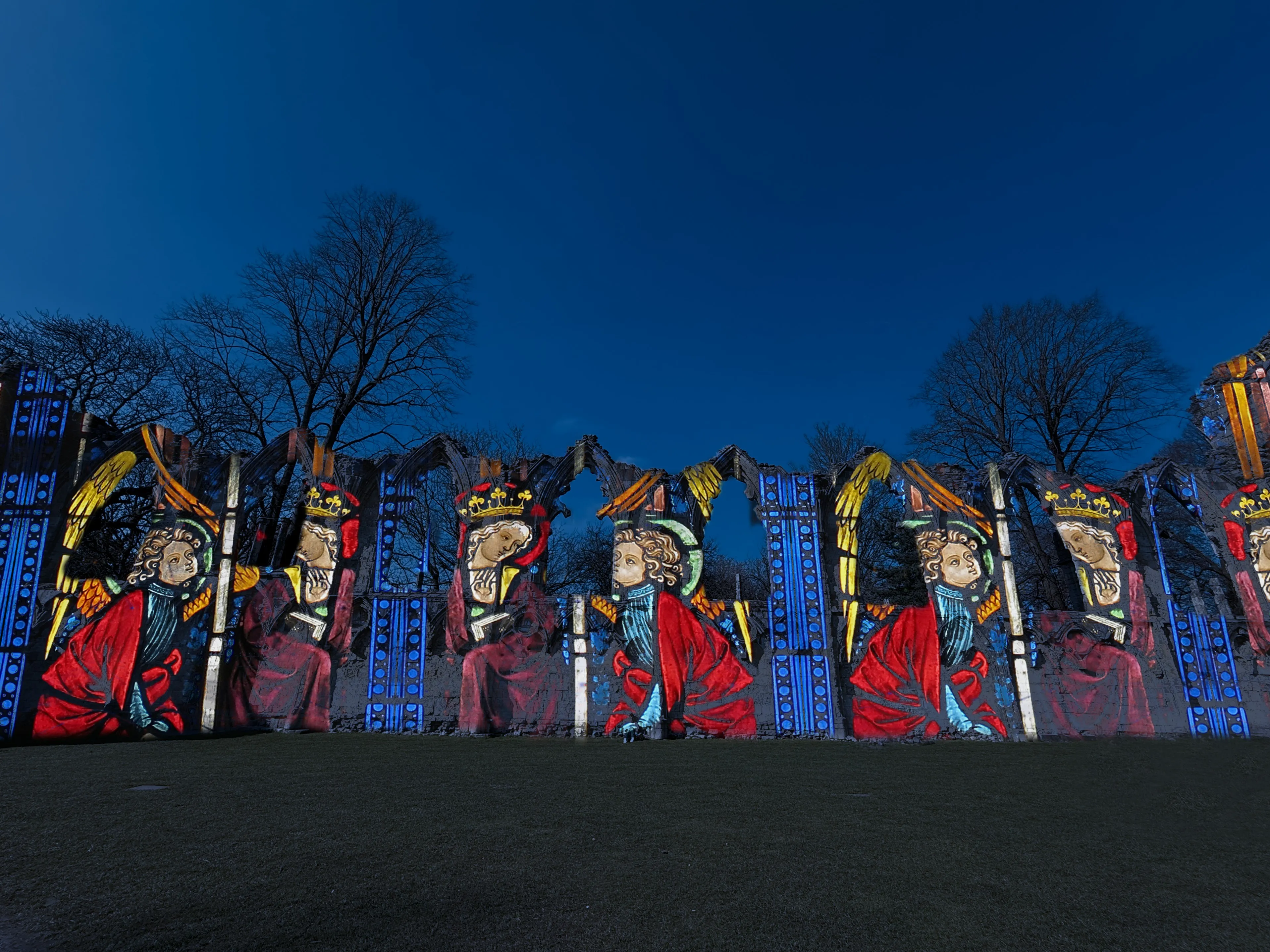 Brightly coloured light projection against ruins in Yorkshire Museum Gardens